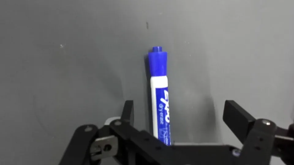 Wrist-camera view: a close-up of the gripper holding a blue marker